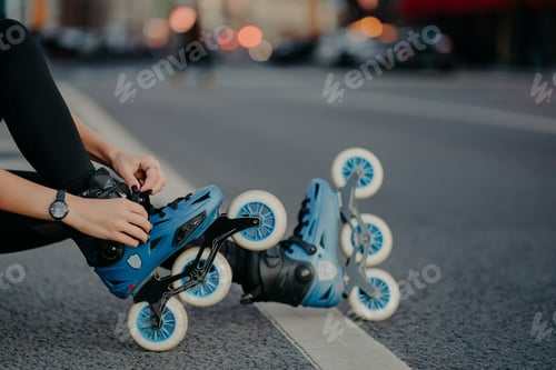 Preview: Legs of unrecognizable woman puts on rollerskates going to have exercises outdoo