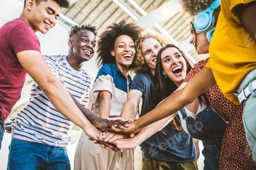 Preview: Multiracial happy young people stacking hands outside