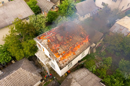 Preview: Aerial view of a house on fire with orange flames and white thick smoke