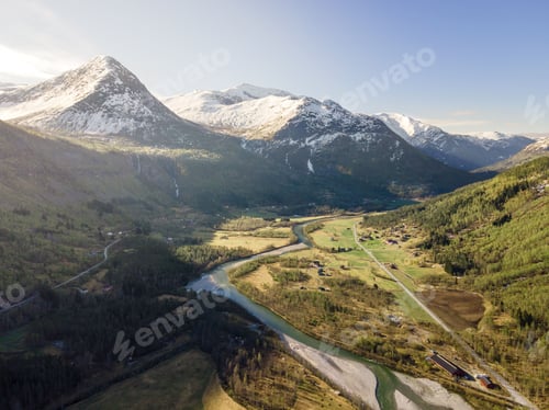 Preview: Aerial shot of a river running through a lush valley surrounded by mountains in Norway.