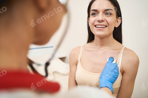Preview: Cheerful brunette female listening to her doctor