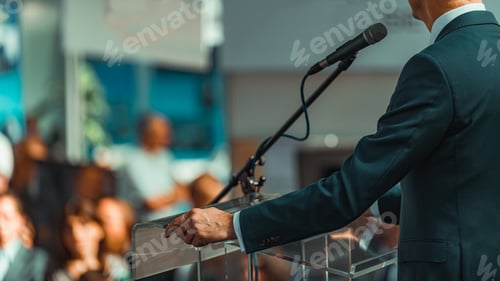 Preview: Male Speaker Standing In Front Of Microphones