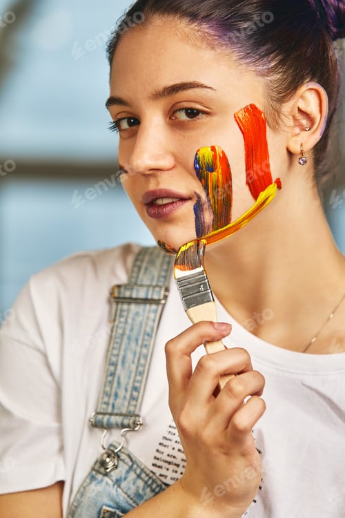 Preview: Beauty art concept, portrait of a young girl painted with different colors of paint. Color demos