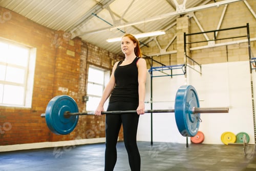 Preview: Woman lifting barbell in gym