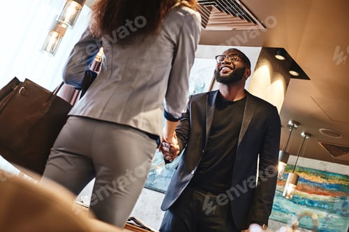 Preview: Team work makes the dream work. Excited businessman and businesswoman are shaking hands. Business