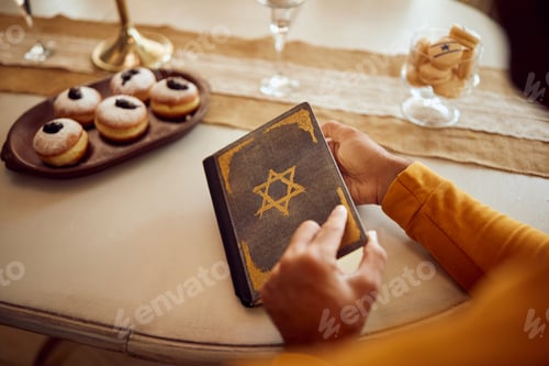 Preview: Close-up of Jewish man reading Tanakh on Hanukkah at home.