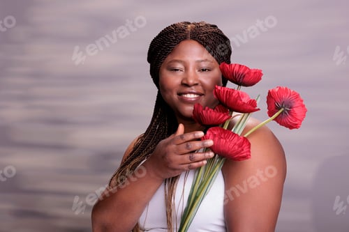 Preview: Smiling pretty woman posing with red poppy branch