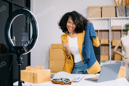 Preview: Fashion blogger concept, Young women selling clothes on video streaming.