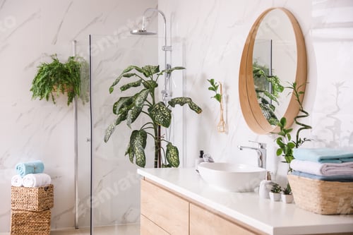 Preview: Beautiful green plants near vessel sink on countertop in bathroom. Interior design