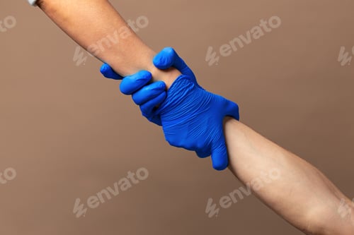 Preview: Handshake in a blue gloves, help concept. Personal hygiene during a pandemic
