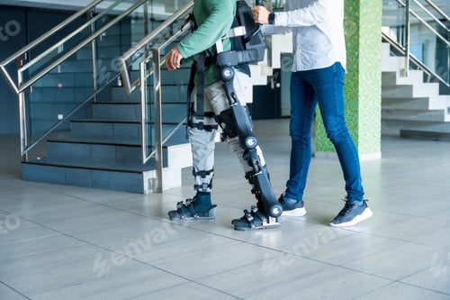 Preview: Mechanical exoskeleton, physiotherapist walking with unrecognizable disabled with robotic skeleton