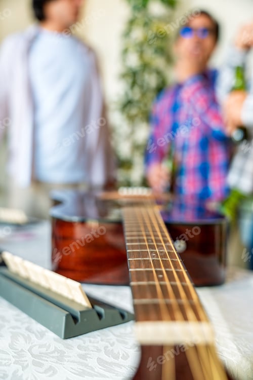 Preview: Acoustic guitar, dominoes and friends gathering, celebrating friendship with music and games