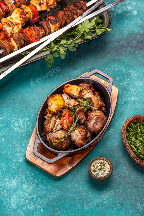 Preview: Bbq grilled meat - pork, chicken and vegetable on cast iron pan. Grilled skewers on blue wooden