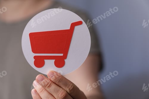 Preview: Closeup shot of a man holding a red and white shopping cart icon on a grey background