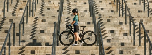 Preview: Website header of Young professional female cyclist in cycling garment and protective gear standing