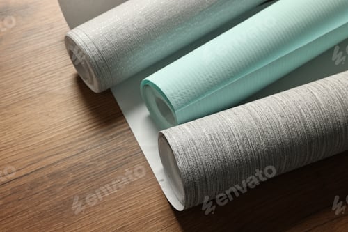Preview: Different stylish wallpaper rolls on wooden table