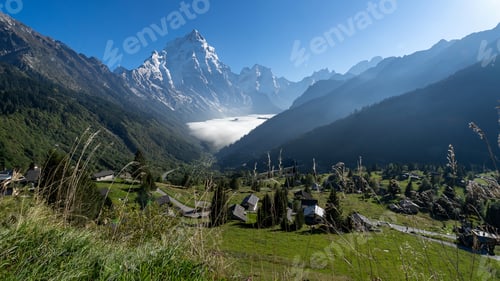 Preview: Scenic view of Swiss Alps landscape with houses in valley amidst mountains