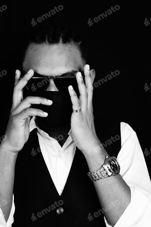 Preview: Black and white portrait of a handsome Indian man with sunglasses in a suit wearing a facemask