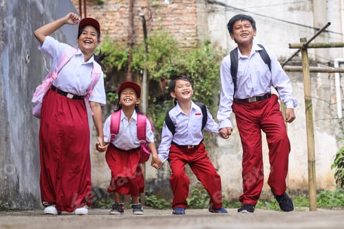 Preview: Attractive elementary school kids wearing school uniform, jumping together.