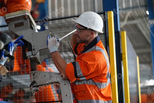 Preview: Engineer Man working at industrial robot in factory industrial. robotic and manufacturing operation.