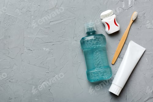 Preview: Mouthwash and other oral hygiene products on colored table top view