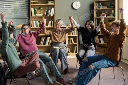 Preview: Diverse Teenagers Raising Joined Hands Celebrating Progress in Group Therapy