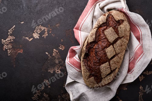 Preview: Freshly baked homemade bread on artisan sourdough rye on brawn stone or concrete background. Top vie