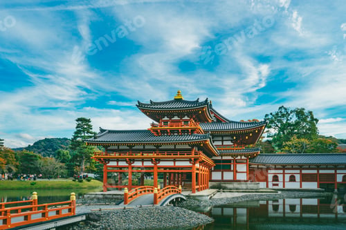 Preview: Wide shot of a red building with grey rooftops near the water under the beautiful cloudy sky