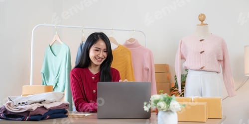 Preview: Asian SME business women use laptop computer checking customer order online shipping boxes at home