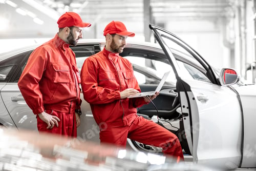 Preview: Auto mechanics diagnosing car with computer