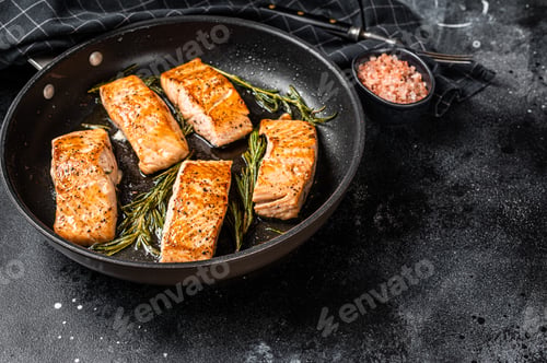 Preview: Roasted Salmon Fillet Steak in a pan with rosemary. Black background. Top view. Copy space