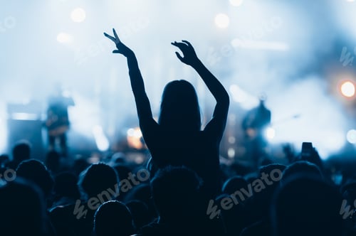 Preview: Silhouette of a woman with raised hands on a concert