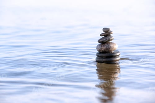 Preview: Stack of dark stones in sea water, space for text. Zen concept