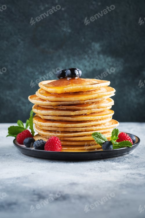 Preview: Delicious pancakes, with fresh blueberries, raspberry and maple syrup or honey on a dark background
