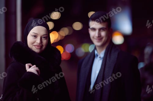 Preview: Happy multicultural business couple walking together outdoors in an urban city street at night near