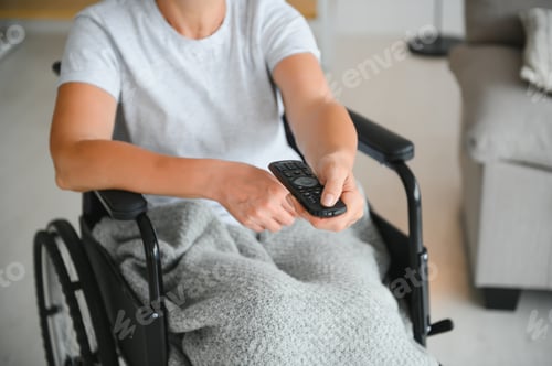 Preview: woman in wheelchair uses a tv remote control.