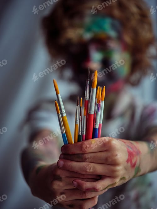 Preview: Unrecognizable dirty boy showing paintbrushes