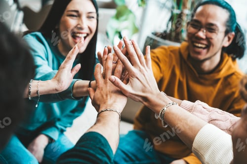 Preview: Group of young people stacking hands together