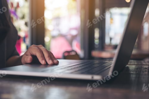 Preview: Closeup image of hands working , touching and typing on laptop keyboard on the table