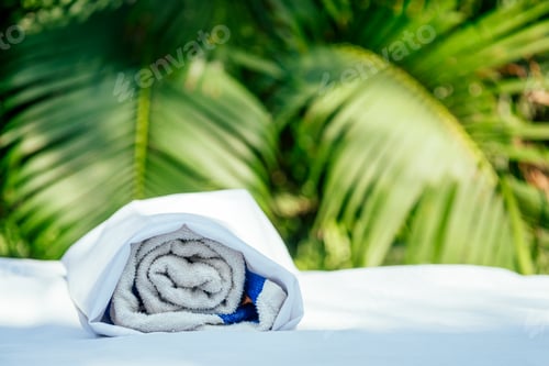 Preview: Spa towel on massaging table background in tropical beach outdoors