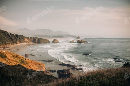 Preview: Tranquil misty view of a rocky beach with majestic mountains in the background in Oregon