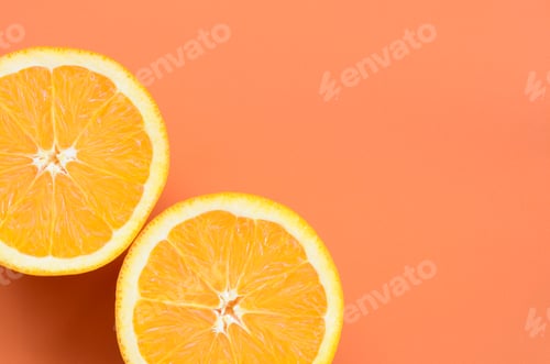 Preview: Top view of a several orange fruit slices on bright background in orange color.