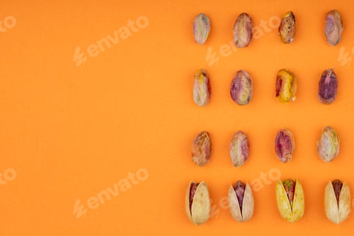 Preview: top view of pistachio nuts on yellow background with copy space