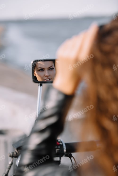 Preview: reflection of beautiful woman in mirror of motorcycle