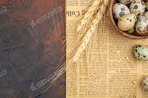 Preview: Above view of farm fresh eggs inside and outside of a wooden pot on an old newspaper on a brown