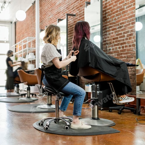 Preview: Hairstylist giving a haircut to a customer at a beauty salon