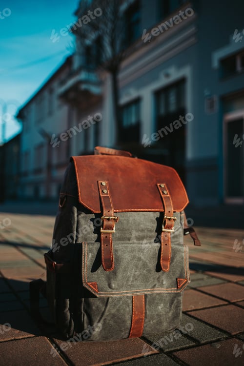 Preview: Vertical closeup shot of a grey and brown rucksack on the ground in the street