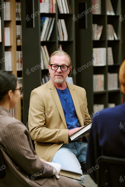 Preview: Middle Aged Caucasian Man Leading Presentation with Book