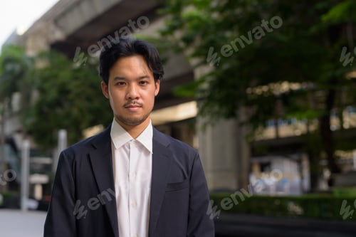 Preview: Portrait of Asian businessman outdoors in the city