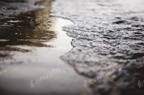 Preview: Closeup shot of sea waves coming up on the shore with a blurred background